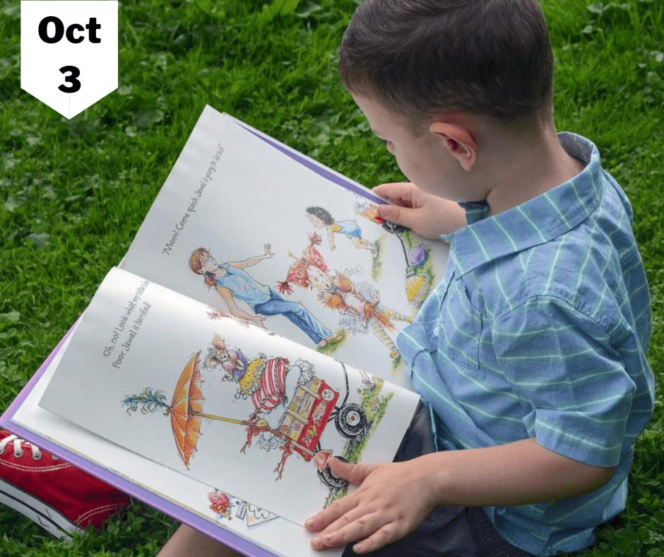 A small boy reading a book with images